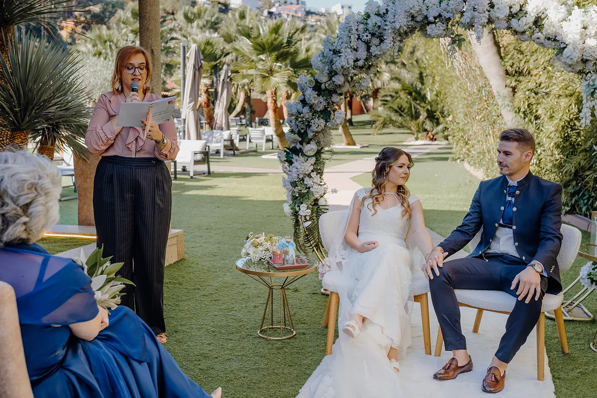 Cerimónia ao ar livre sob um arco de flores brancas